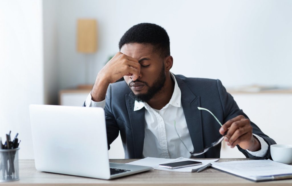 African american businessman tired of long time work on laptop